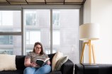 Woman sitting on a couch reading a book.