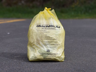 A full yellow Council rubbish bag.