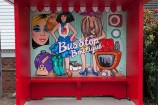 Bus shelter: 'Bus stop boutique' with 2 glamorous women.