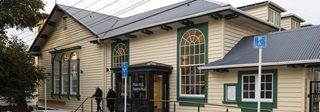 The front of Newtown community centre, a large wooden building with stained glass windowns.