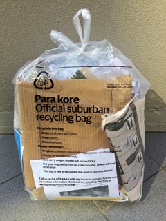 Official suburban recycling bag containing paper and cardboard.